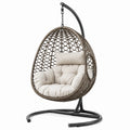 Fauteuil suspendu en rotin synthétique avec coussin en polyester beige et support en acier